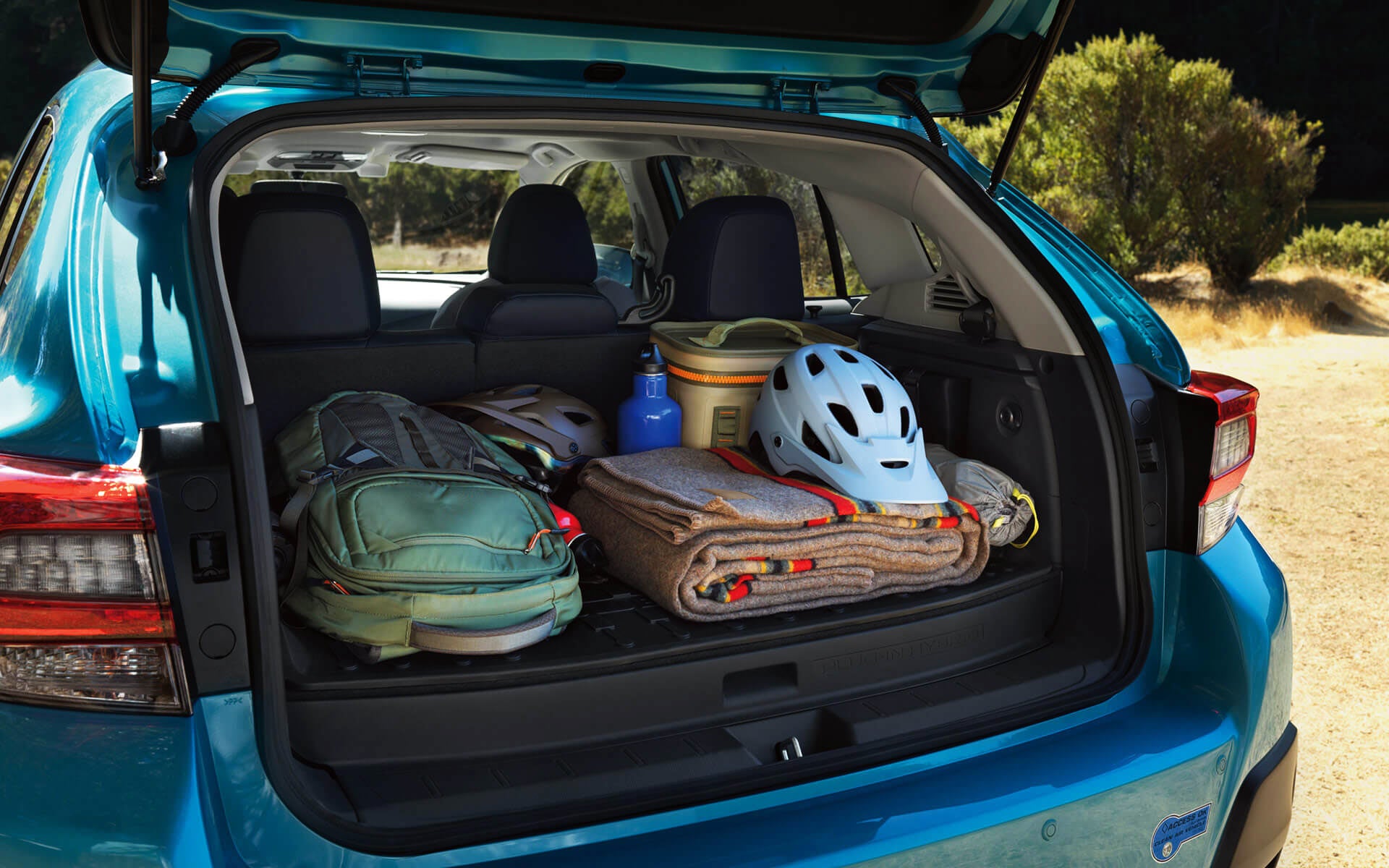 A backpack, blanket, and bike helmet in the rear cargo area of a Crosstrek Hybrid | Dutch Miller Subaru in Charleston WV