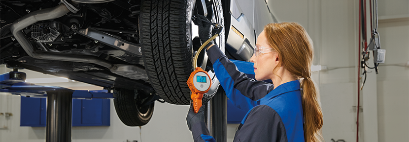 A Subaru technician checking tire pressure. | Dutch Miller Subaru in Charleston WV