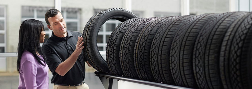 Subaru service representative showing customer a tire. | Dutch Miller Subaru in Charleston WV