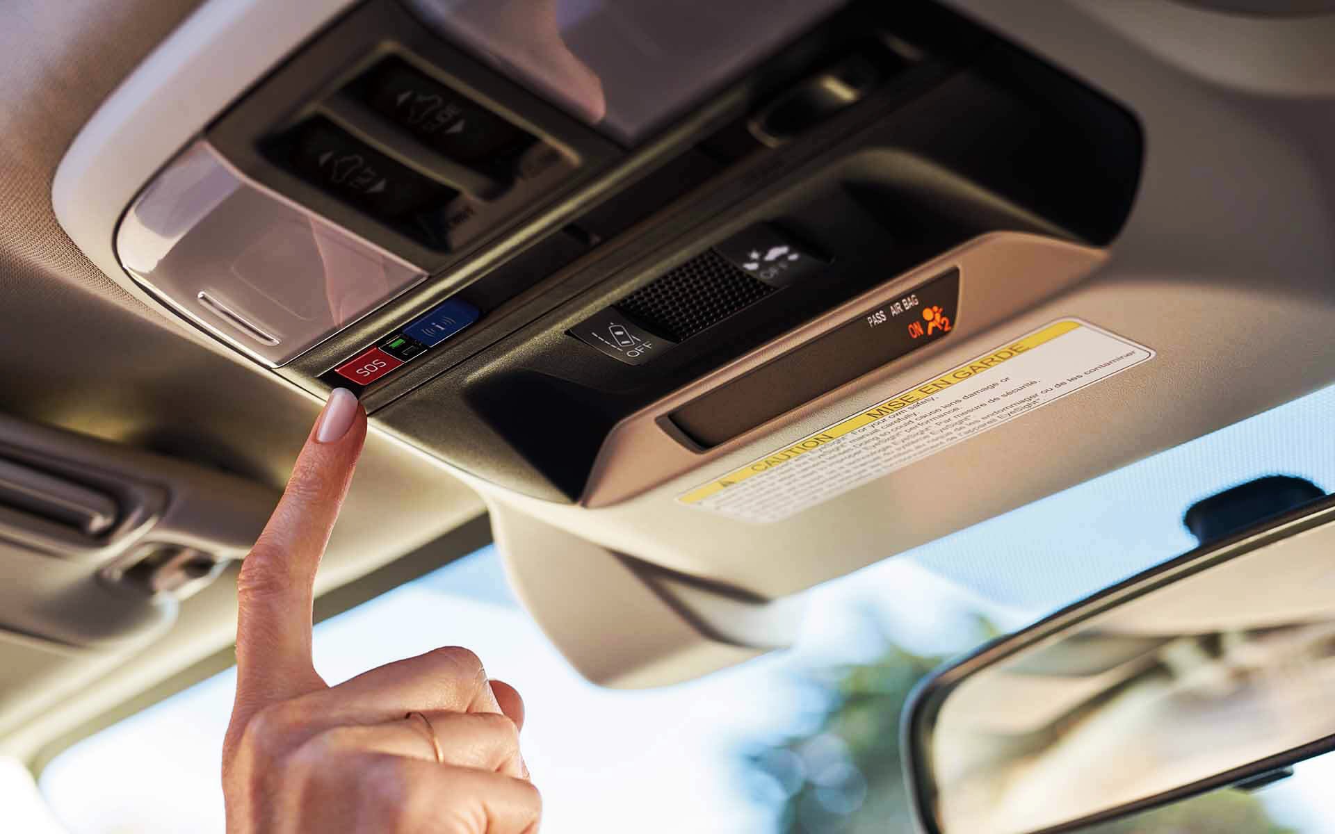 A finger pressing the Crosstrek Hybrid's SOS emergency assistance button | Dutch Miller Subaru in Charleston WV